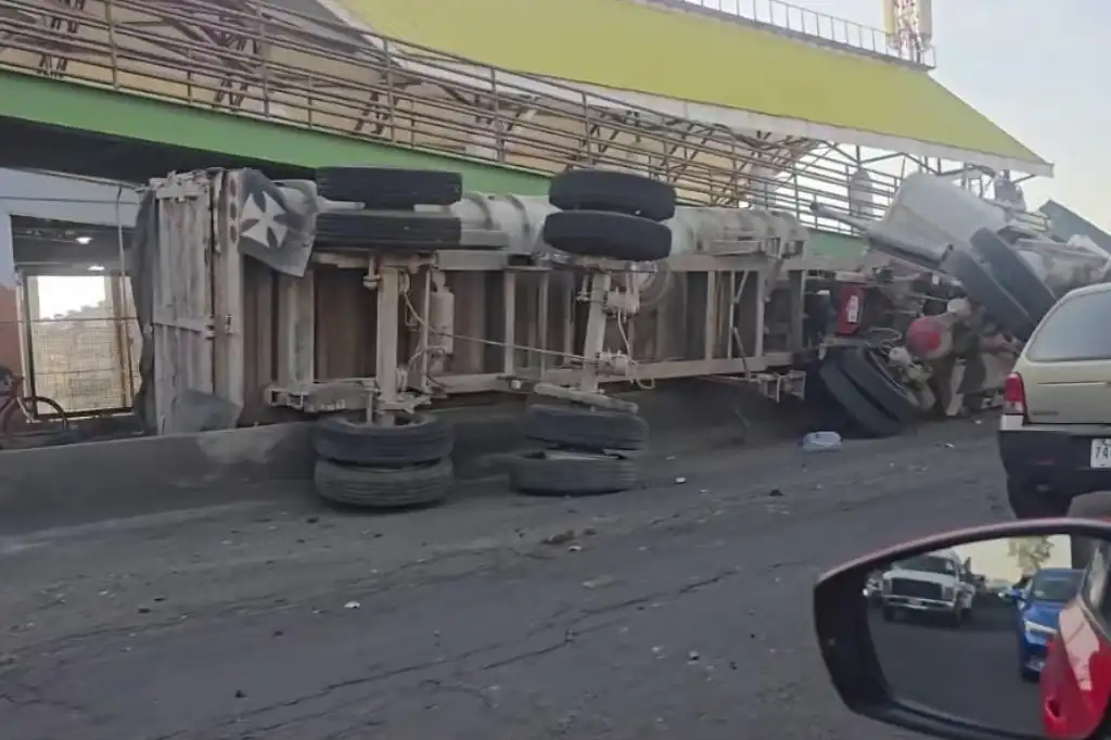 Un tráiler que transportaba aproximadamente cinco toneladas de arena volcó la mañana de este martes sobre la avenida Carlos Hank González, conocida como avenida Central, en el municipio de Ecatepec, Estado de México.